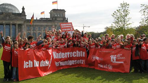 Kinder vom Deutschen Kinderhilfswerk halten PVC Banner vor dem deutschen Reichstag